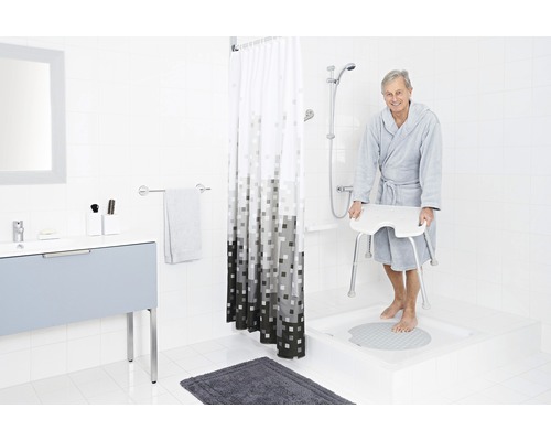 Badezimmer mit Duschhocker, Duschvorhang und Waschtisch