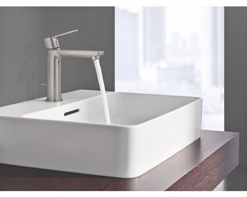 Un lavabo avec un robinet et de l''eau courante est visible sur un plan de toilette.