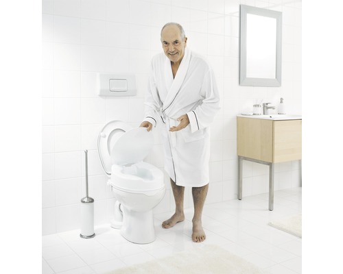 Homme en peignoir avec rehausseur de toilettes dans la salle de bain