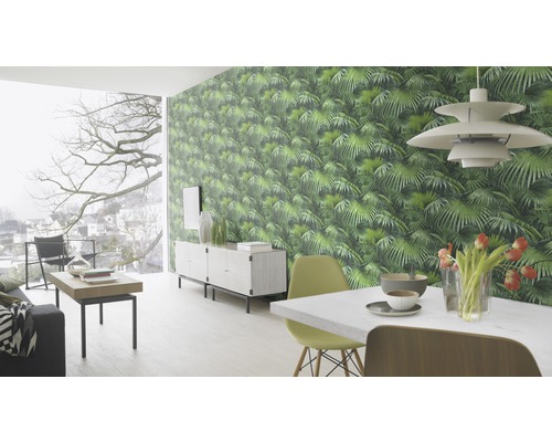 Wohnzimmer mit grün gemusterter Dschungeltapete, Esstisch und Sideboard