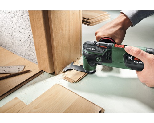 Outil multifonction oscillant travaillant sur un cadre de porte