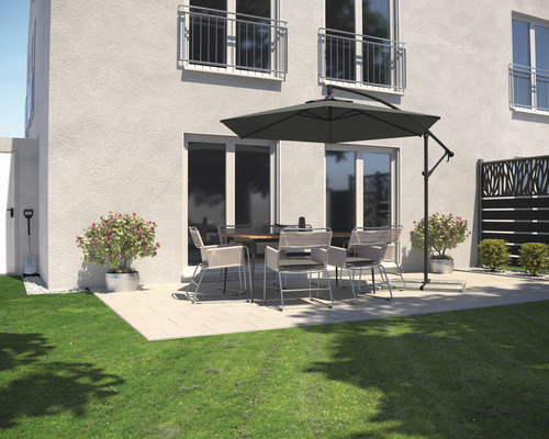Terrasse avec table de jardin, chaises et parasol à côté d'une maison.