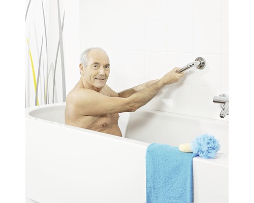 Un homme tient une barre d''appui dans la baignoire pour plus de sécurité