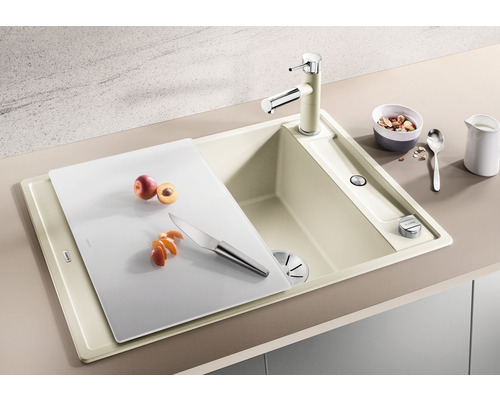 Spüle mit Armatur, Schneidebrett und Obst in einer hellen Küche