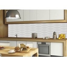 Scène de cuisine avec plan de travail, évier, robinet, cuisinière et panneau mural à motif ondulé