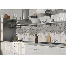 Scène de cuisine avec armoires blanches, évier en acier inoxydable, cuisinière et hotte.