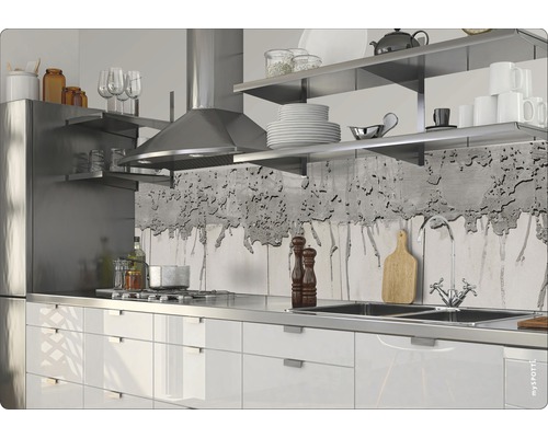 Scène de cuisine avec armoires blanches, évier en acier inoxydable, cuisinière et hotte.