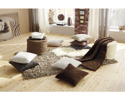 Dekoratives Zimmer mit Kissen, Poufs, Teppichen und Decken für eine gemütliche Atmosphäre