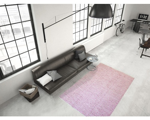 Ansicht eines Zimmers mit Sofa, Teppich und großen Fenstern