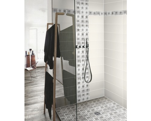 Douche à l''italienne avec paroi en verre, robinetterie de douche et porte-serviettes dans la salle de bains.