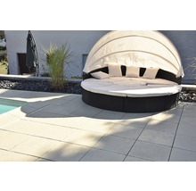 Gartenszene mit Bodenplatten und runder Sonnenliege mit Baldachin