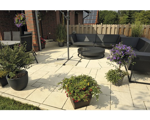 Terrasse mit Gartenmöbeln, Sonnenschirm und Pflanzenkübeln