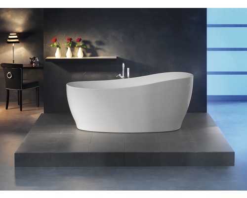 Freistehende Badewanne in einem Badezimmer mit Fliesenboden, Stuhl, Tischlampe und Dekor