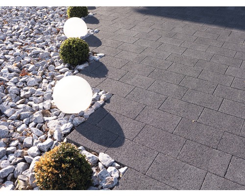 Gartenweg gepflastert mit Betonsteinen, dekoriert mit Kies, Kugelleuchten und Buchsbaumkugeln