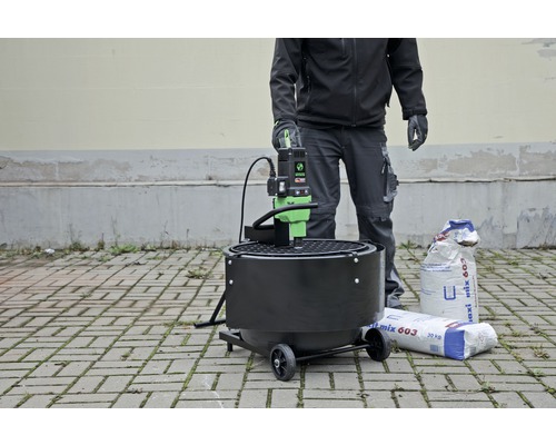 Machine à mortier avec personne et deux sacs de mortier prêt à l''emploi