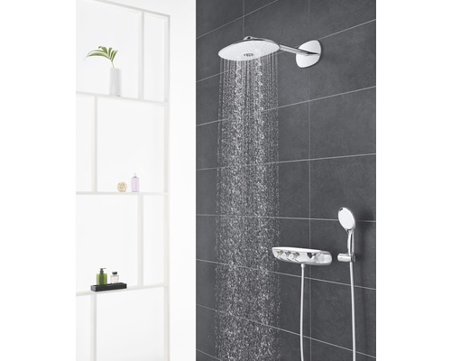 Duschsystem mit Kopfbrause, Handbrause und Thermostat vor grauer Wand mit Wasserstrahl