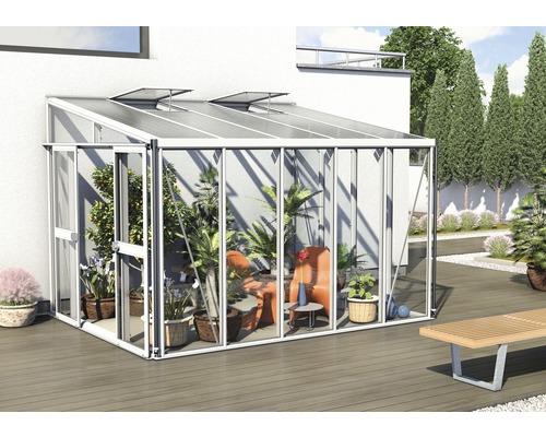 Serre avec plantes et sièges dans le jardin.