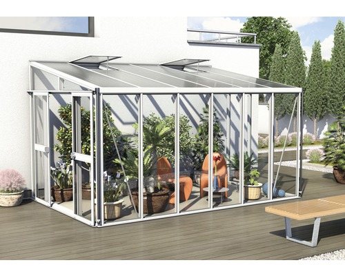 Serre avec plantes et mobilier de jardin sur une terrasse
