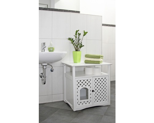 Salle de bain avec lavabo, plante et meuble bas blanc avec portes grillagées.