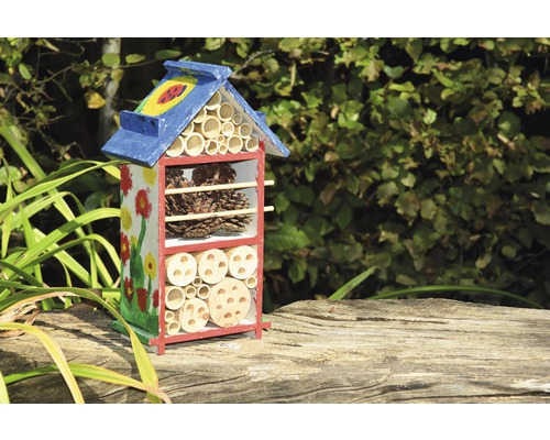 Insektenhotel mit verschiedenen Füllmaterialien und Blumenmuster