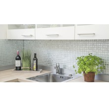 Küchenspüle mit Armatur, Kräutertopf und Dekoration auf Arbeitsplatte vor Mosaikfliesen