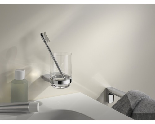 Porte-gobelet mural avec brosse à dents, articles de toilette sur un lavabo