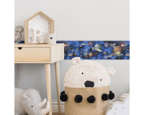 Frise de papier peint sur le thème de l''espace dans une chambre d''enfant avec table et décoration