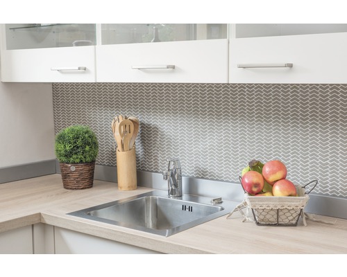 Évier de cuisine avec robinet, accessoires en bois et décoration sur un plan de travail clair