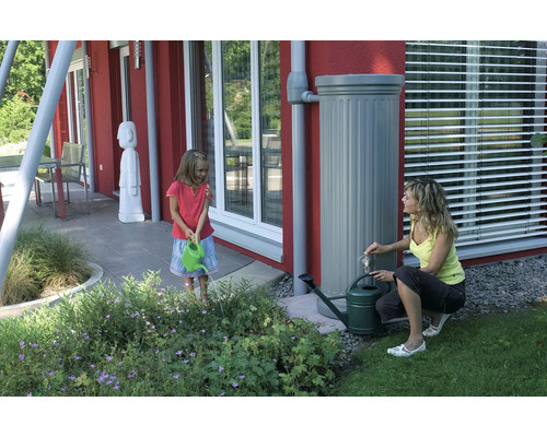 Scène de jardin avec enfant, femme, récupérateur d''eau de pluie et arrosoirs