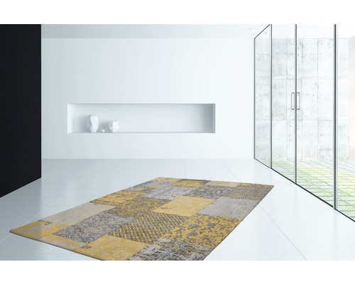 Moderner Teppich mit Patchworkmuster in einem hellen Raum.