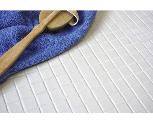 Weisse Mosaikfliesen mit Bürste und Handtuch