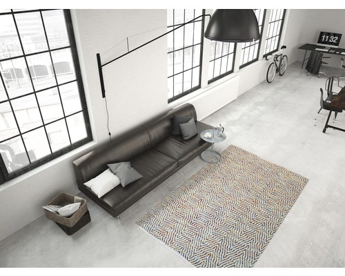 Ansicht eines Wohnzimmers mit Sofa, Teppich und Fensterfront