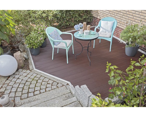 Jardin aménagé avec terrasse en bois, coin salon et plantes