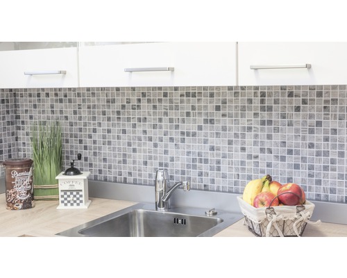 Scène de cuisine avec des carreaux de mosaïque, un évier et des éléments décoratifs.