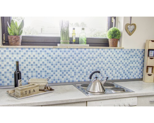 Scène de cuisine avec fond en mosaïque bleue, boîte à thé, bouteille de vin et plaque de cuisson