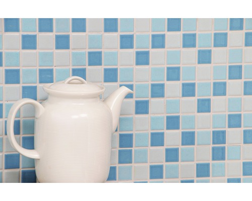 Théière en céramique devant un fond de carreaux de mosaïque