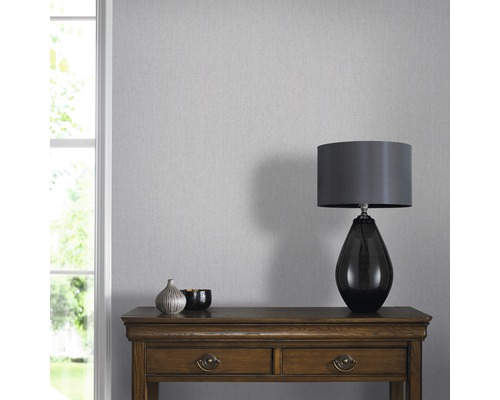 Heller Raum mit grauer Tapete, Tisch und Lampe