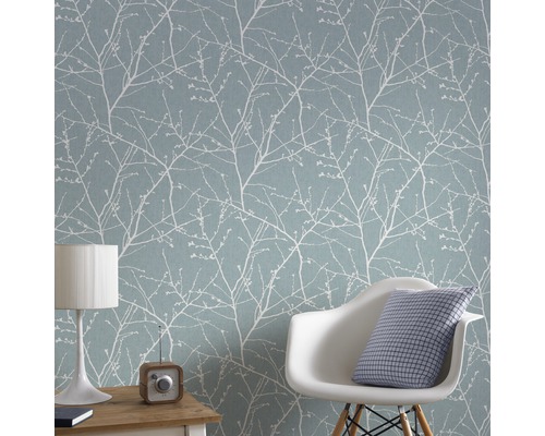 Salon avec papier peint à motifs bleu clair, chaise, lampe de table et radio