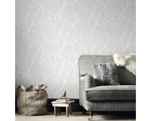 Salon avec papier peint gris à motif de branches, canapé gris et décoration