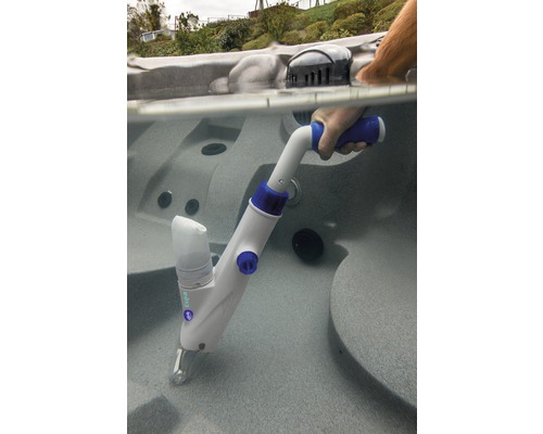 Une personne utilise un nettoyeur de piscine portable dans un bain à remous.
