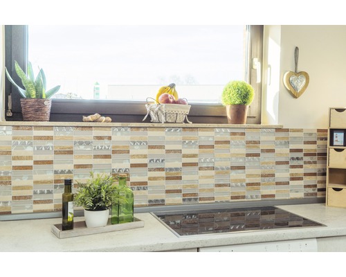Küchenszene mit Mosaikfliesen an der Wand, Arbeitsplatte mit Pflanzen und Kochfeld