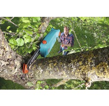 Mann benutzt Hochentaster zum Beschneiden eines Astes.