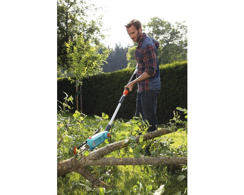 Mann benutzt eine Astsäge zum Zerteilen von Ästen im Garten.