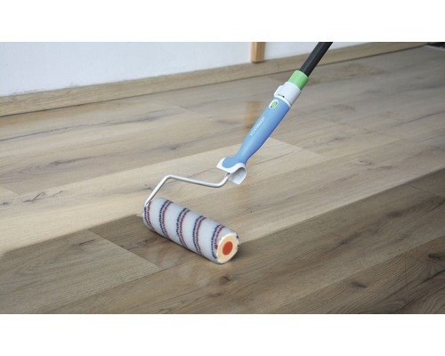 Farbroller mit Teleskopstiel auf einem Holzboden