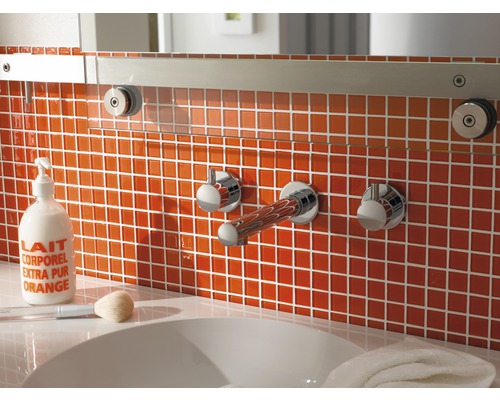 Salle de bain avec carrelage orange, lavabo et robinetterie