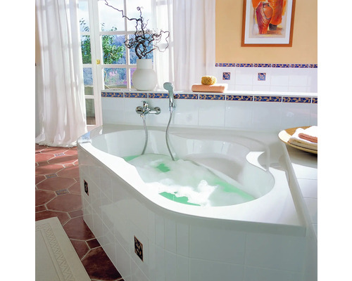 Salle de bain avec baignoire d''angle, robinetterie, décoration et fenêtre