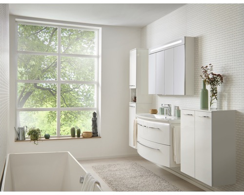 Helles Badezimmer mit Badewanne, Fenster und weißen Badmöbeln