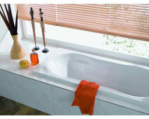 Salle de bain lumineuse avec baignoire, décoration et stores