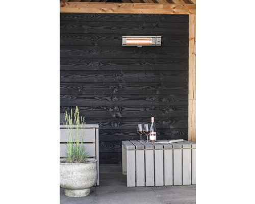 Terrasse mit Infrarotheizstrahler, Holzwand, Tisch, Weinflasche und Gläsern