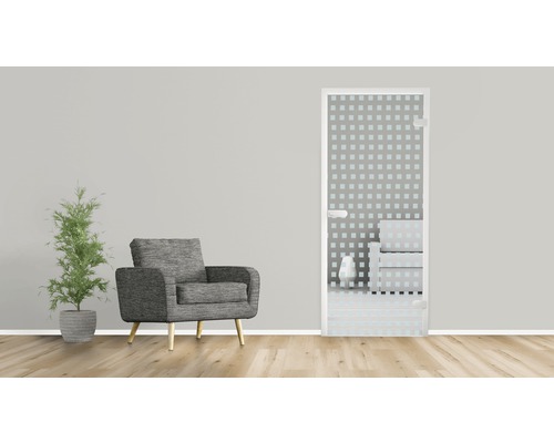 Salle de bain avec porte en verre, fauteuil et plante d''intérieur.